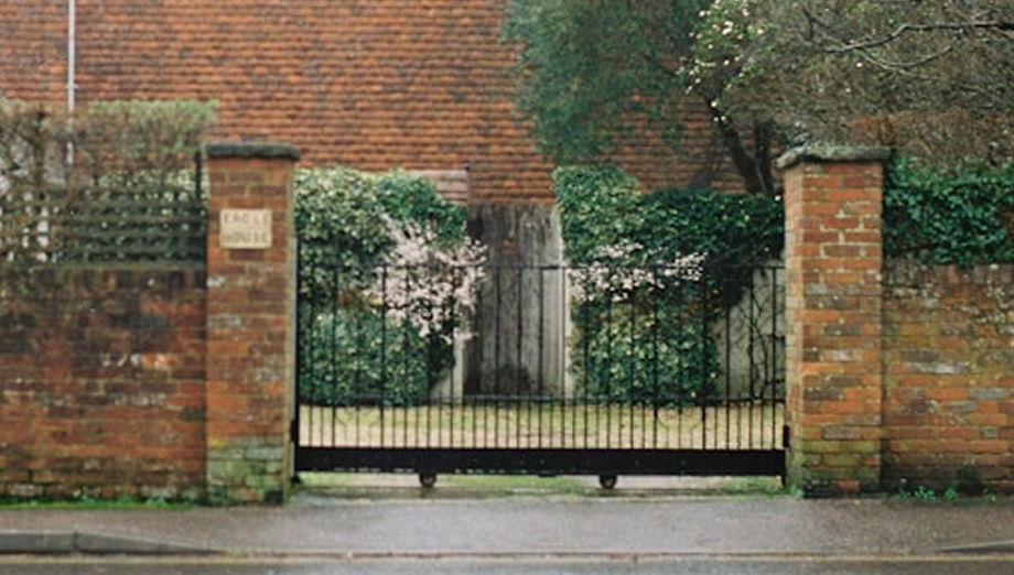Black metal gate between brick pillars
