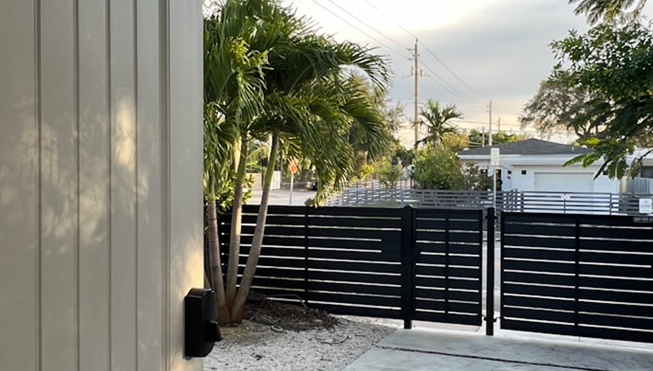 Black horizontal slat gate next to a modern home