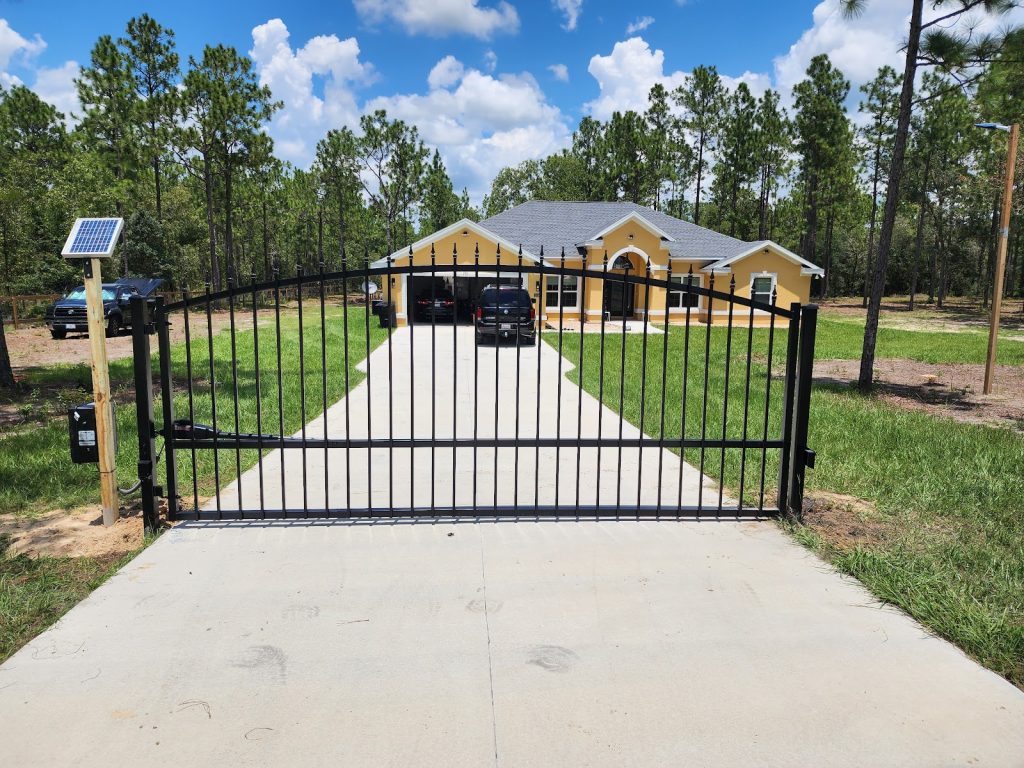 Black aluminum dual swing driveway gate installed by KSM Gates in front of a Tampa Bay home